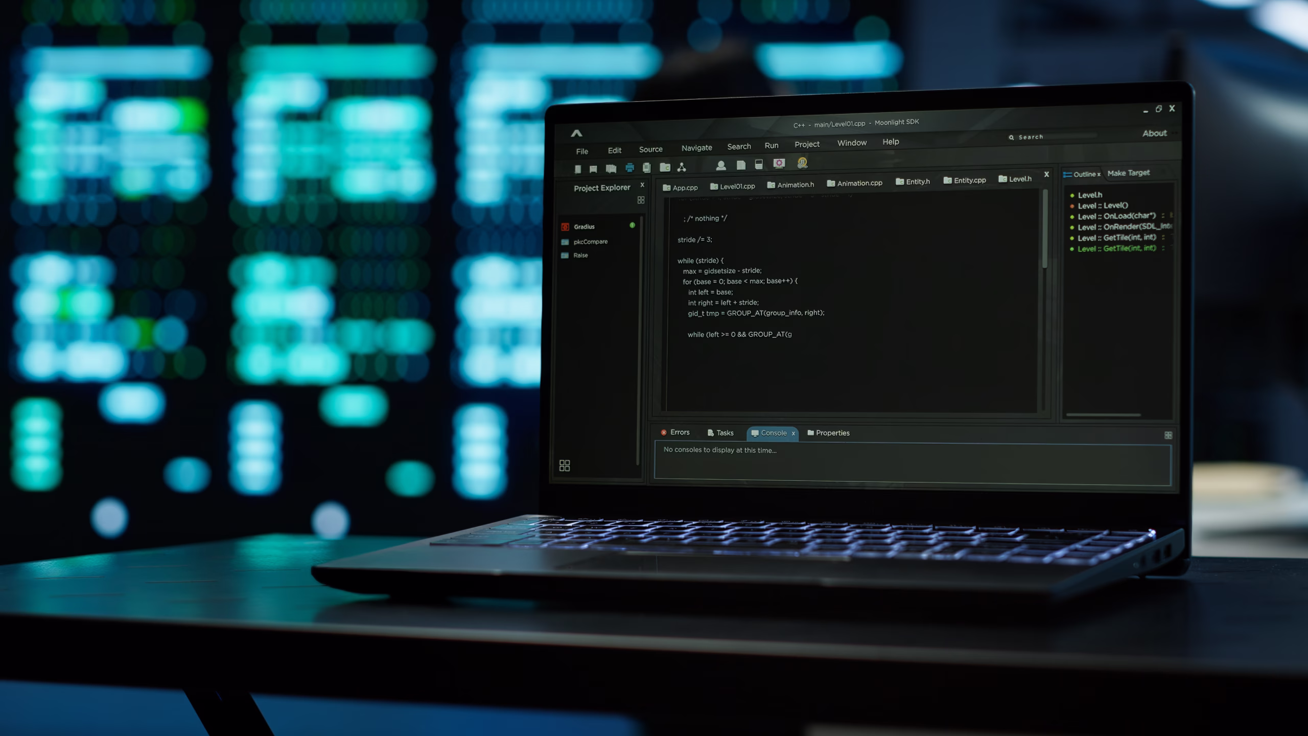 Open laptop on a desk displaying code in a development environment, with illuminated data center servers in the background.