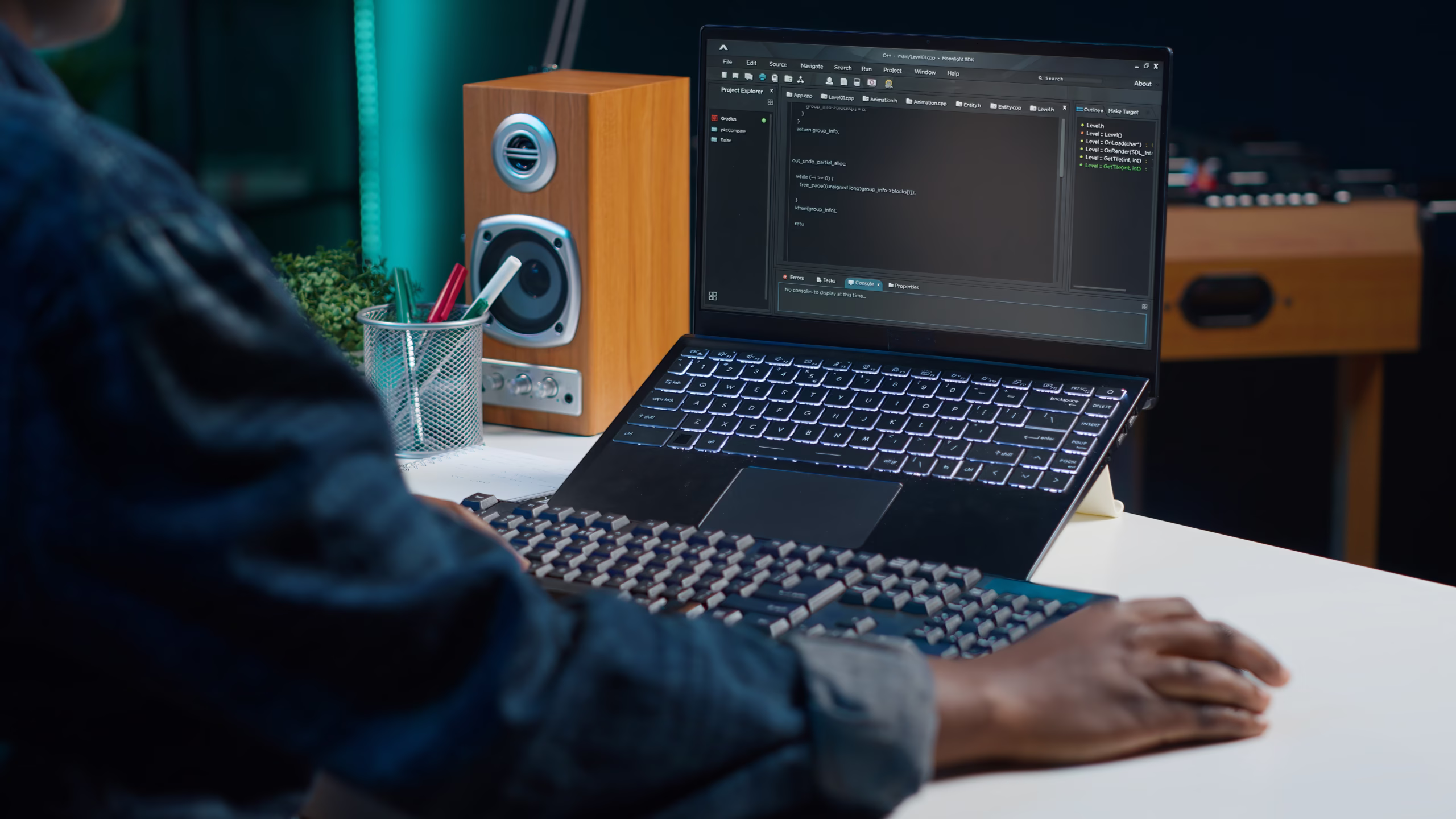 Developer coding on a laptop in a remote work setup, with a code editor open on screen