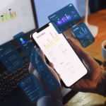 Mão segurando um smartphone com gráfico de linha na tela, cercado por painéis de interface translúcidos (calendário, tela de login, portfólio e assinatura) em tons de azul e rosa, com notebook e caderno desfocados ao fundo.